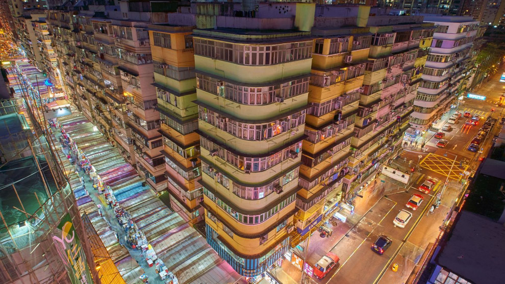 Mong Kok is one of Hong Kong's liveliest districts and includes popular markets, shopping streets, stalls and malls. This photo shot from a roof of an old building. Lights under those tents make it looks more colourful and full of energies.