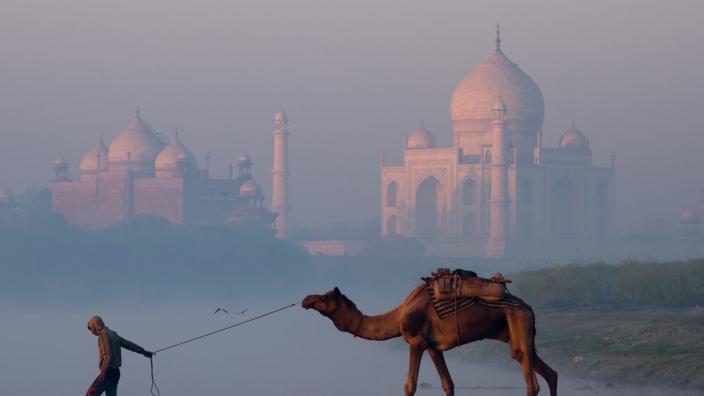 During the night, dense fog rises off the Yamuna river and hides the Taj Mahal. At sunrise the marble of the Taj Mahal begins to reflect the growing light, which, filtered by the drifting and dissipating fog reveals the Taj Mahal glowing with increasing beauty. For the people who live nearby it is just another day at the office. For those of us visiting it is a spectacular experience.