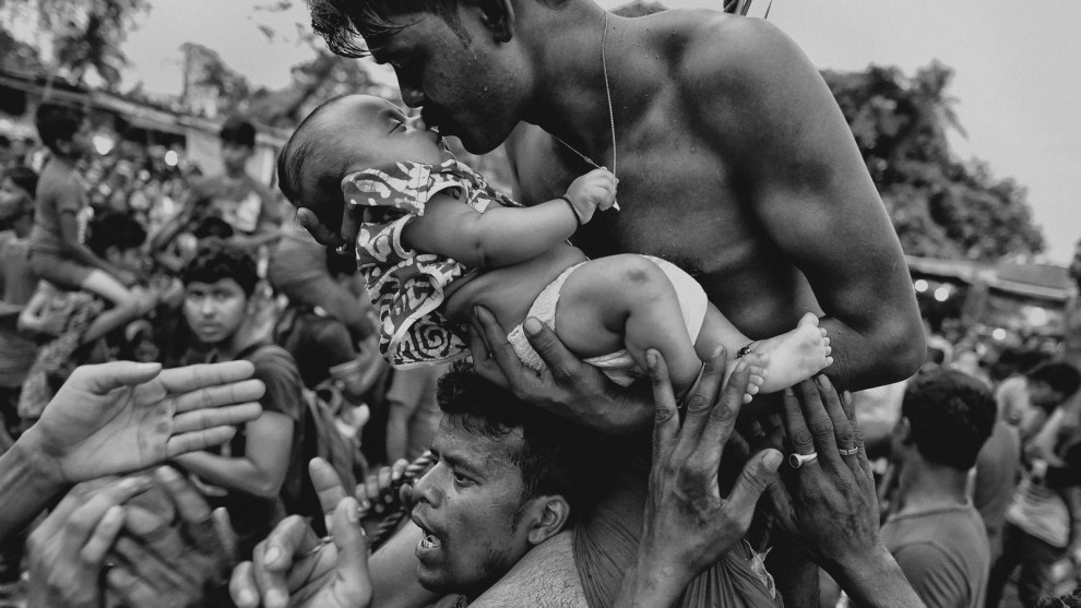 3rd Place in People. Photograph and caption by Avishek Das / 2018 National Geographic Photo Contest. A Hindu devotee kisses his newborn baby during the Charak Puja festival in West Bengal, India. Traditional practice calls for the devotee to be pierced with a hook and sometimes swung from a rope. This painful sacrifice is enacted to save their children from anxiety. While covering the festival, I was able to view the religious practice from the perspective of Hindu devotees. I tried to capture the moment of love and bonding between a father and his child&mdash;and show a father&rsquo;s concern for his little son.