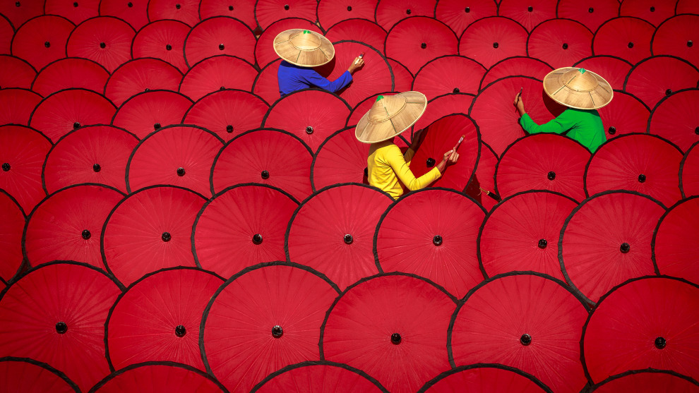 Photographer: Zarni Myo Win, Myanmar

"Three women workers painting traditional Myanmar umbrellas. This image was taken to create the colours red, green, blue and yellow. I set up this photograph up with these colours deliberately. The umbrellas are traditional in Myanmar and women workers paint them in their daily working life. When I saw these beautiful umbrellas, I was inspired by the colours and patterns."