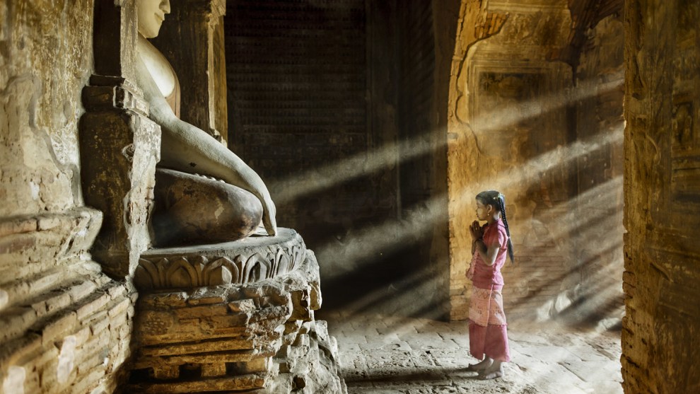 Stefano Pensotti, Bagan, Myanmar. Prayer time in one of little temples in the plain of Bagan - a young girl stops on her way to school. Canon EOS 5D
Mark II, EF24mm f/1.4L USM lens,f2, 1/40s, ISO 800.