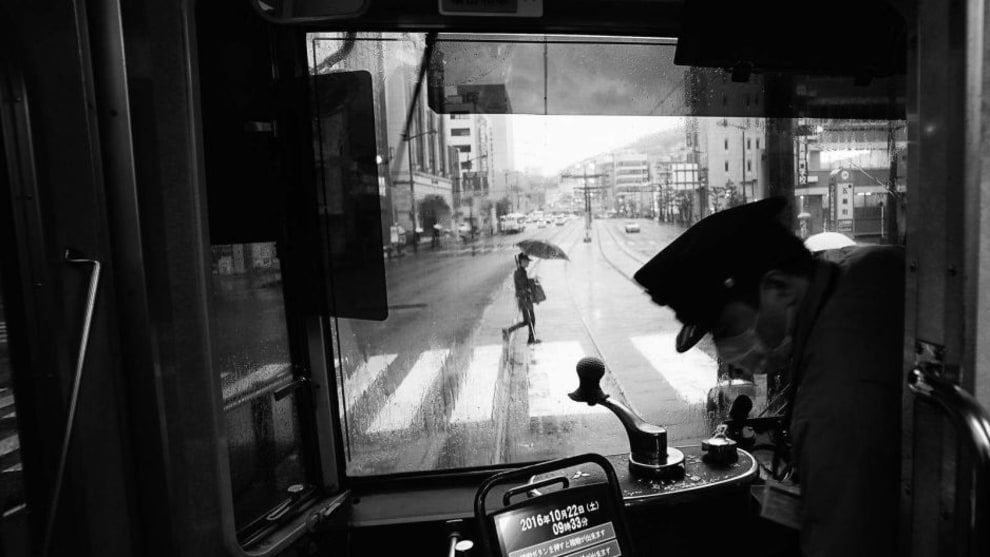 Another Rainy Day in Nagasaki, Kyushu. This is a view of the main street from a tram in Nagasaki on a rainy day. The tram is vintage, but retrofitted with modern ticketing equipment. A conductor is no longer on board-onlythe lone driver. The quiet streetscape seen through the front windshield of the tram somehow caught my attention.This view presents quite a contrast to busy urban centers in Japan, such as Tokyo and Osaka. The ride on a vintage tram through the relatively quiet main street was a memorable experience during our week-long visit to the historic city of Nagasaki. First place, Cities category. National Geographic Travel Photographer of the Year Contest. CREDIT: Photo and caption by Hiro Kurashina / National Geographic Travel Photographer of the Year Contest