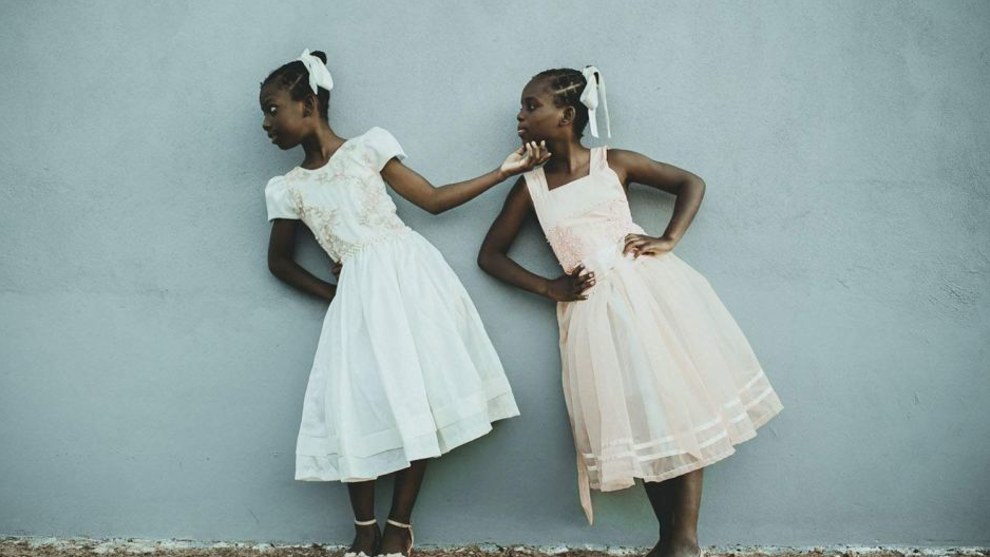 Leida and Laelle - I Will Lift You Up
Since 2016, I've been involved with Haitian immigrants and refugees living in my city, Estrela. I have become friends with some families, and especially with twin sisters, Le&iuml;da and La&euml;lle. They say living in Brazil is like living in paradise-very different from the reality of their country of origin. They dream of becoming models and teachers, as a way to earn money to bring their other relatives from Haiti to Brazil, to live all near one another. On this day, they were playing in front of their home, improvising exercises to develop their imagination and creativity, as if they were actresses, and playing an imitation game with poses. La&euml;lle reached for Leida's face and lifted her head up, showing her where she should look. At this brief moment, I took the photo. Second place, People category. National Geographic Travel Photographer of the Year Contest. CREDIT: Photo and Caption by Tati Itat / National Geographic Travel Photographer of the Year