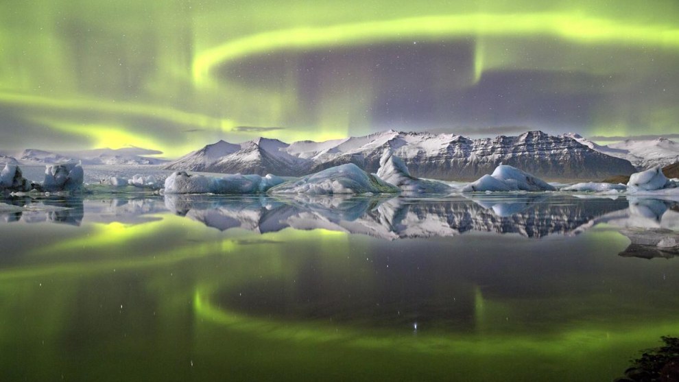 &copy; James Woodend. Aurora over a Glacier Lagoon. Astronomy Photographer of the Year 2014 winner.

"Although it is not a strong aurora, sometimes these make the best reflection shots. The water was very still &ndash; you can see the icebergs floating in the lagoon and their reflections. In the background is the Vatnaj&ouml;kull Glacier.
