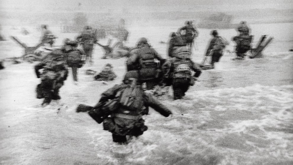 Robert Capa
International Center of Photography/Magnum Photos

American soldiers landing on Omaha Beach, D-Day, Normandy, France. June 6, 1944.

&ldquo;The water was cold, and the beach still more than a hundred yards away. The bullets tore holes in the water around me,
and I made for the nearest steel obstacle&hellip; It was still very early and very gray for good pictures, but the gray water and the gray sky made the little men, dodging under the surrealistic designs  of Hitler&rsquo;s anti-invasion brain trust, very effective.&rdquo;

&ndash;Robert Capa, Slightly Out of Focus (1947)