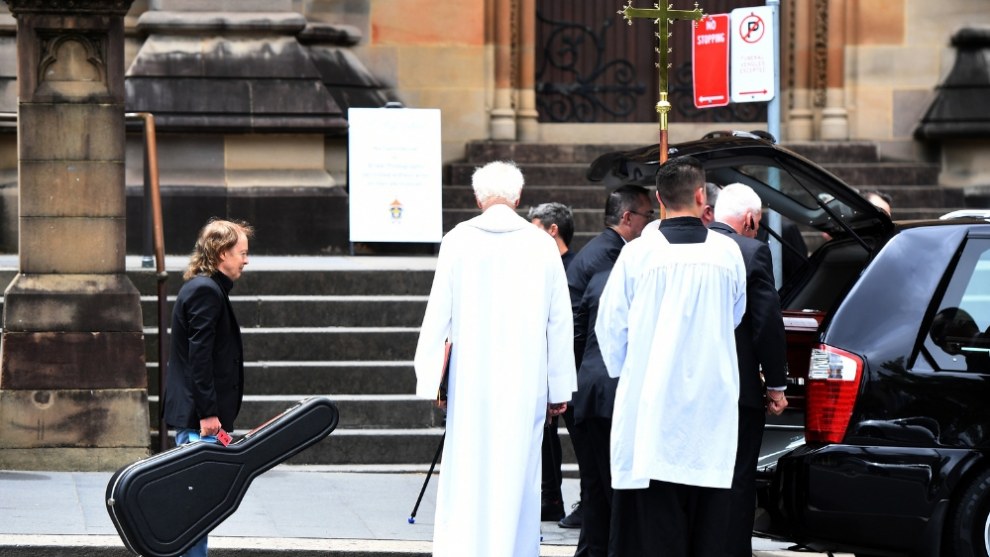 Angus Young waits to place a guitar in the hearse carrying the casket of his brother, AC/DC co-founder and guitarist Malcolm Young. The funeral was held at St Mary&rsquo;s Cathedral in Sydney in November 2017. &copy; Dean Lewins