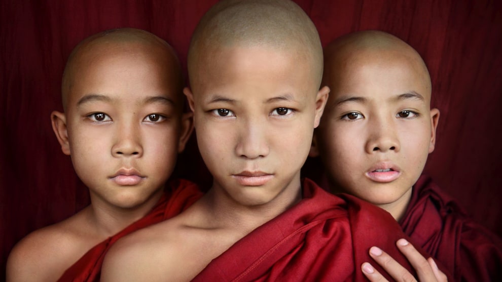Three novice monks in Myanmar photographed in a formation that balances well and is very symmetrical. The hand on the shoulder breaks the symmetry just slightly, and adds an extra layer of emotion to the photo. Nikon D800, 24-85mm f/2.8-4 lens. 1/200s @ f7.1, ISO 500.