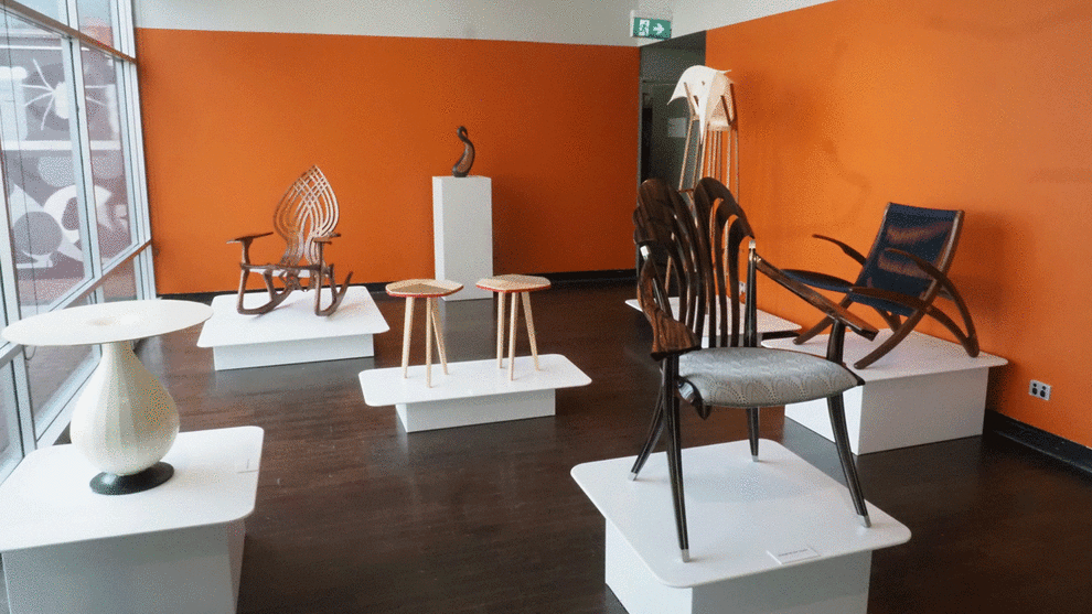 Left to right: Symbiosis exhibition of works at JamFactory Adelaide by Studio Woodworkers Australia members Tim Quirk (occasional table), Gray Hawk (rocker), Ian Bell (sculpture on pedestal at rear), Ruth Thompson's standing lamp at rear and side tables in centre, Gesto armchair by Rhys Jones far right and chair by Gray Hawk in the foreground.
