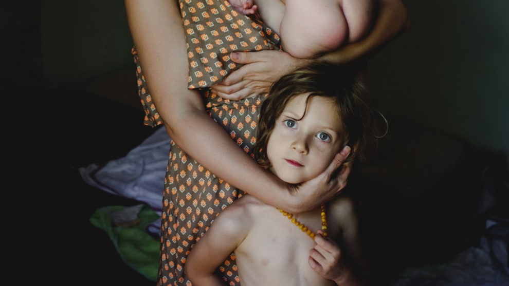 FIRST PLACE &ndash; Irmina Walczak & S&aacute;vio Freire &ndash; Mama
&ldquo;This photo is a portrait of us in the early days of the arrival of our son. It represents time in which each of us was searching and reviewing its place in this new organism called family. This picture is about being mother of two and becoming an octopus in order to supply physical and psychological needs of your offspring. It is also about being father of two and feeling unable and distant. Finally, it is about being the older child and losing the lap as well as pleading for attention.&rdquo;