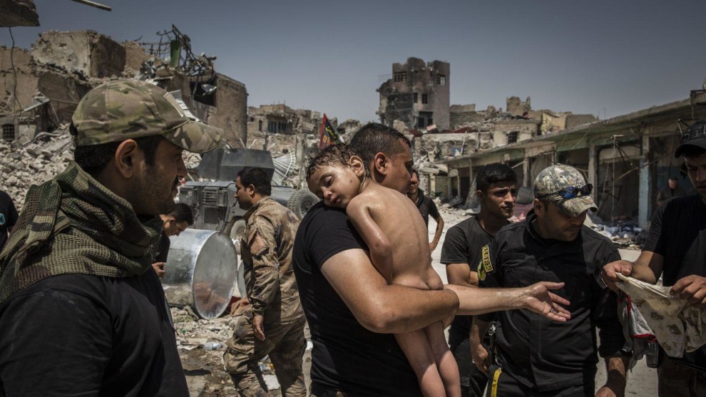 The Battle for Mosul. World Press Photo of the Year Nominee. &copy; Ivor Prickett. An unidentified young boy, who was carried out of the last ISIS-controlled area in the Old City by a man suspected of being a militant, is cared for by Iraqi Special Forces soldiers. Commissioned by The New York Times.