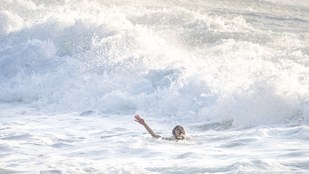 A woman screams and raises her arm as she is caught in a rip at Bronte Beach in Sydney during very rough surf conditions. &copy; Jenny Evans