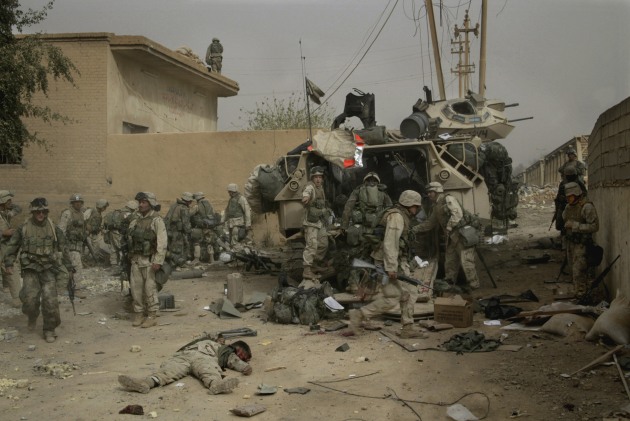 &copy; Gary Knight. US Marines clean up their dead and wounded after a 130mm shell exploded in a direct hit on one of their armoured vehicles during an attack on Dyala Bridge during the invasion of Iraq. April 2003.