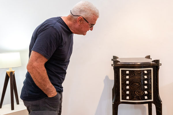 A visitor admires the Collector's Cabinet made by Ian Higgs. Warwick Wright&rsquo;s Apollo lamp is to the left. Photo: Julijana Griffiths