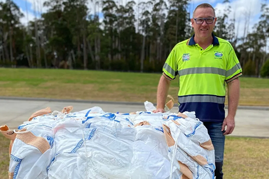 Fonterra's production operator, Travis Palmer, with a pile of one-tonne bags that can now be recycled through the big bag recovery program.