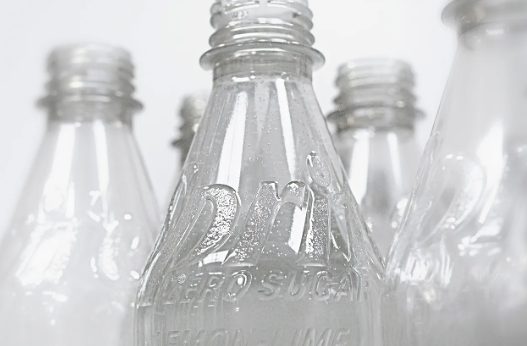 The trial will see bottles lose their labels in a bid to cut down on material.