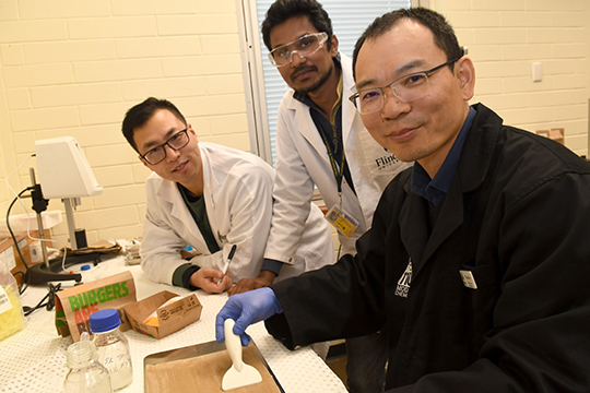 (l-r) Flinders University researchers Peng Su, Chanaka Mudugamuwa and Dr Zhongfan Jia testing the biopolymer coating for potential use in fast-food and other wrappers.