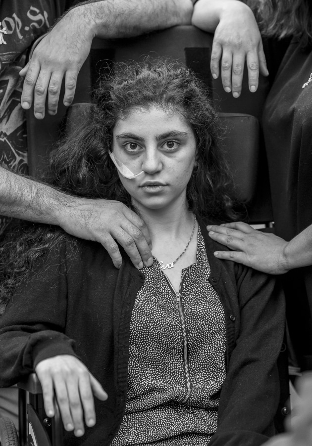 World Press Photo of the Year Nominee. &copy; Tomek Kaczor, Poland, for Duży Format, Gazeta Wyborcza. Awakening. A 15-year-old Armenian girl who has recently woken from catatonic state brought on by Resignation Syndrome, sits in a wheelchair, flanked by her parents, in a refugee reception center in Podkowa Leśna, Poland.