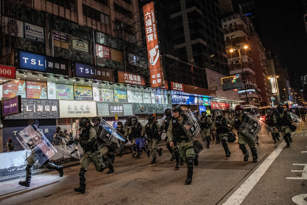 Nominee for the World Press Photo Story of the Year. &copy; Nicolas Asfouri, Denmark, Agence France-Presse. Hong Kong Unrest. Riot police run towards protesters on Nathan Road in Hong Kong, on 1 December 2019.