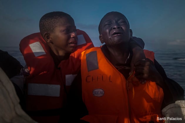 General News - Second Prize, Singles. Left Alone.
An 11-year-old girl from Nigeria (left), who said her mother died in Libya, cries next to her 10-year-old brother aboard an NGO rescue boat, on 28 July 2016. The children had sailed for hours in an overcrowded rubber boat with other refugees during a rescue operation on the Mediterranean Sea, about 23 kilometers north of Sabratha, Libya.
Libyan smugglers often take advantage of refugees, charging anywhere from $750 to $3500 for a place on typically dangerous boats they say are heading to Italy. &copy; Santi Palacios.