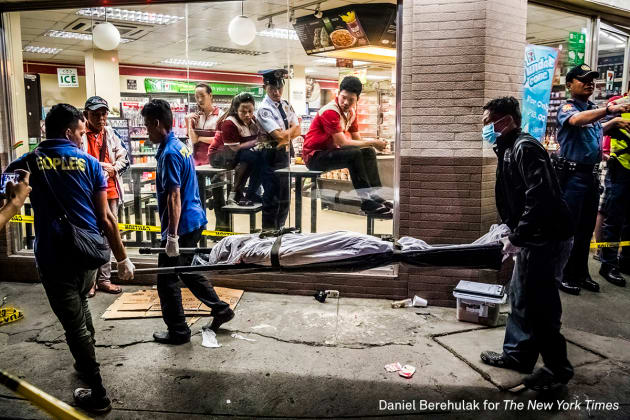 General News - First Prize, Stories. They Are Slaughtering Us Like Animals. Funeral parlor workers carry away the body of Edwin Mendoza Alon-Alon (36) who was killed by an unknown gunman on the road in front of a 7-Eleven store in Manila, Philippines. &copy; Daniel Berehulak, for The New York Times.