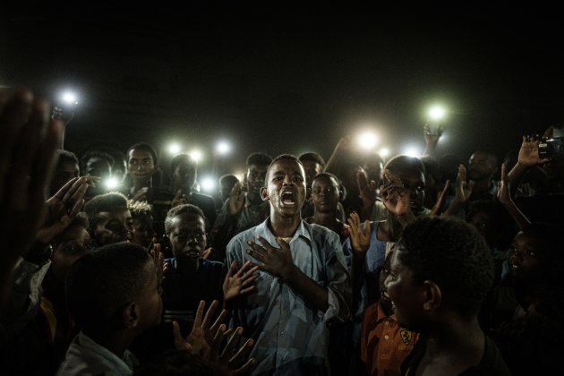 General News Singles Nominee. &copy; Yasuyoshi Chiba, Japan, Agence France-Presse. Straight Voice. A young man, illuminated by mobile phones, recites a poem while protestors chant slogans calling for civilian rule, during a blackout in Khartoum, Sudan, on 19 June.