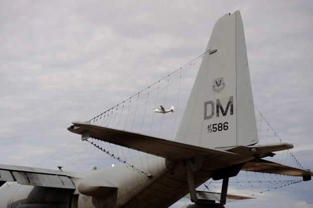 A Japan Maritime Self Defense Force C-130R Hercules flies over a grounded US Air Force EC-130 belonging to the 41st Electronic Combat Squadron at Davis-Monthan Air Force Base, Arizona on 12 July, 2014.

Credit: US Defense