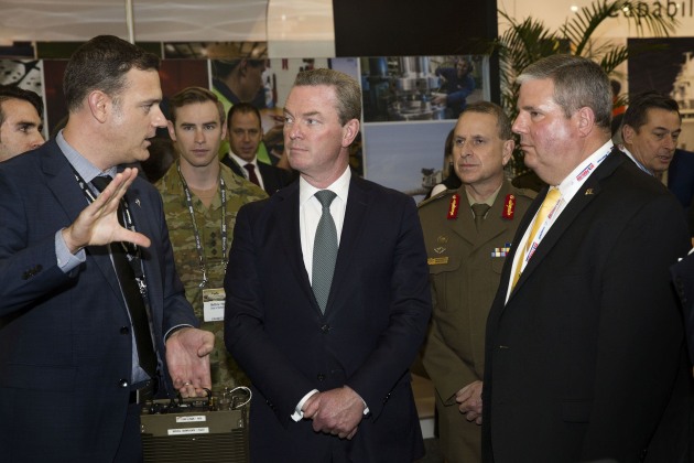 Minister for Defence Industry Christopher Pyne listens to Boeing Defence Australia Land 2072 program director Lee Davis (L) as managing director Ken Shaw (R) looks on. Credit: Defence