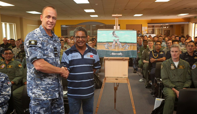AVM Steven Roberton is officially presented with the Exercise PITCH BLACK 18 artwork from Mr Joe Raymond of the Larrakia people, surrounded by International multi-nation Air Force representatives. Defence