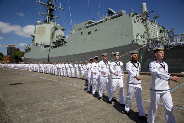 Members of the ship's company march on board during HMAS Brisbane's commissioning ceremony held at Garden Island, Sydney. Defence