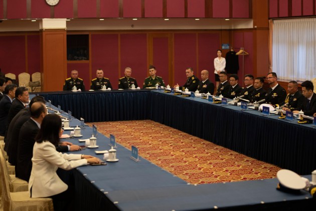 The commanding officer of HMAS Melbourne, seated centre right, during a port call in China on the way north. Credit: Defence