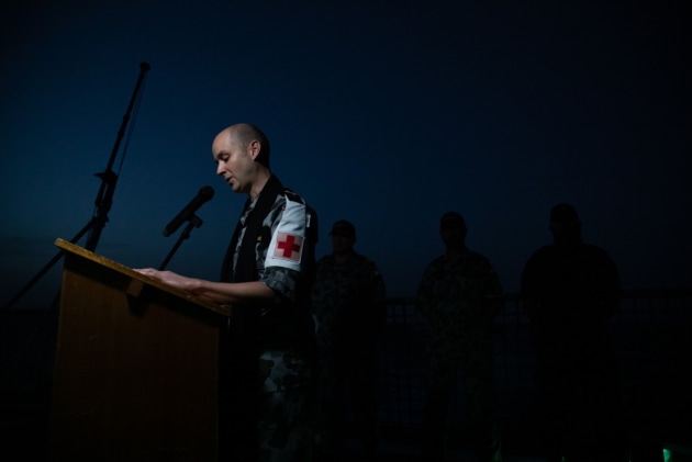 Chaplain James Sutherland leads the ship's company of HMAS Ballarat in prayer during an Anzac Day Dawn Service held at sea. (Defence)