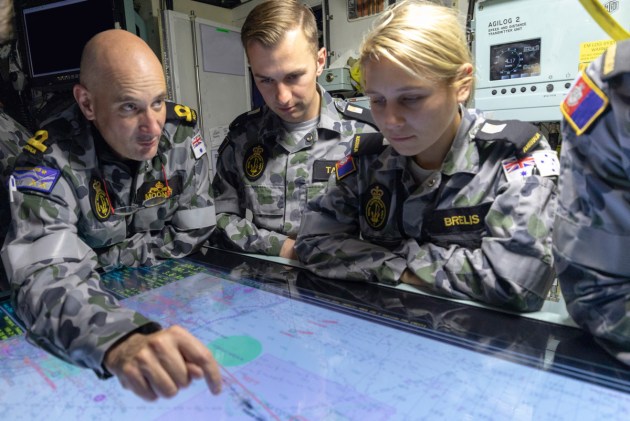 Sub-Lieutenant Jason Mooney explains the Plotting Table to a group of  RAN Midshipman on board HMAS Farncomb. Defence