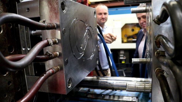 Mr Jim Grose (Axiom Managing Director) and Mr Ben Barona (DST Group, Defence) examine the injection moulding die used to manufacture face mask strut components in support of Operation COVID-19 Assist. (Defence)