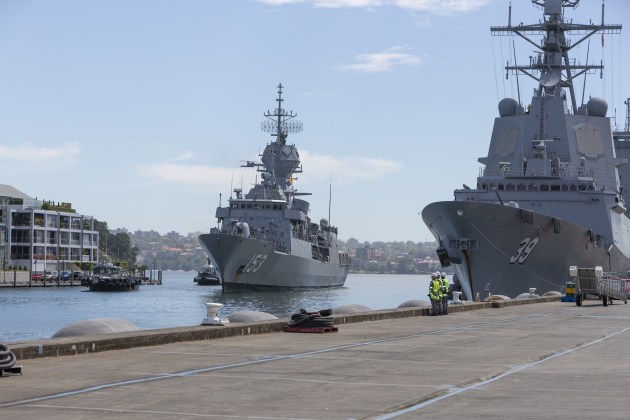 HMAS Stuart passes HMAS Hobart as she prepares to come alongside her homeport of Fleet Base East in Sydney. (Credit: Defence)