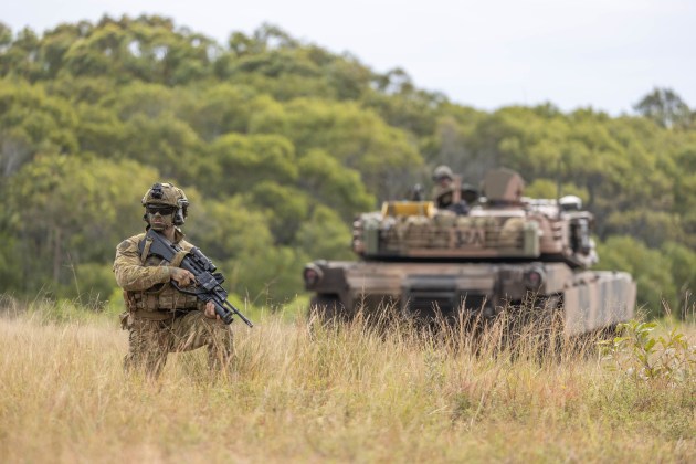 A soldier from 3rd Battalion, the Royal Australian Regiment, maintains a perimeter defence by an M1A1 Abrams Main Battle Tank. (Credit: Defence)