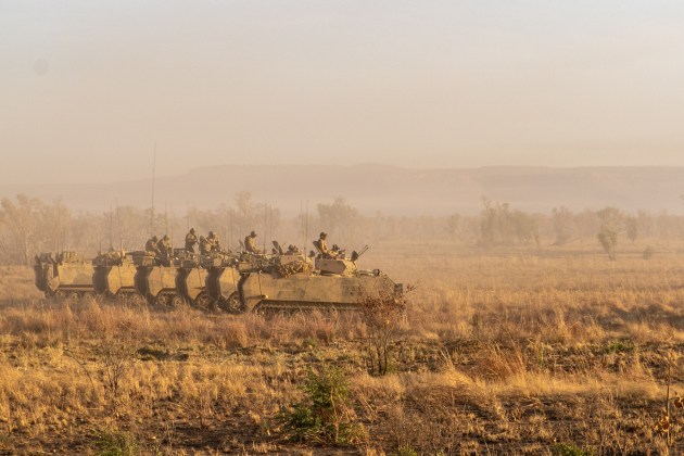 M113 AS4 Armoured Personal Carriers from 7th Battalion, Royal Australian Regiment, wait at a staging area before a live-fire assault. (Defence)