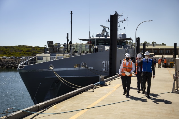Assistant Minister for Defence, Andrew Hastie (right), and Austal senior staff walk down a wharf at the Austal Ships shipyard in Henderson, WA. (Defence)