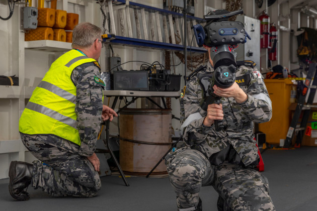 L-R: Officer in charge Ships Safety and Survivability School Lieutenant Commander Paul Fawbert, RAN takes Able Seaman Boatswains Mate Lucinda Allanson through the virtual reality fire fighting training system on board HMAS Brisbane at Fleet Base East, NSW. (Defence)