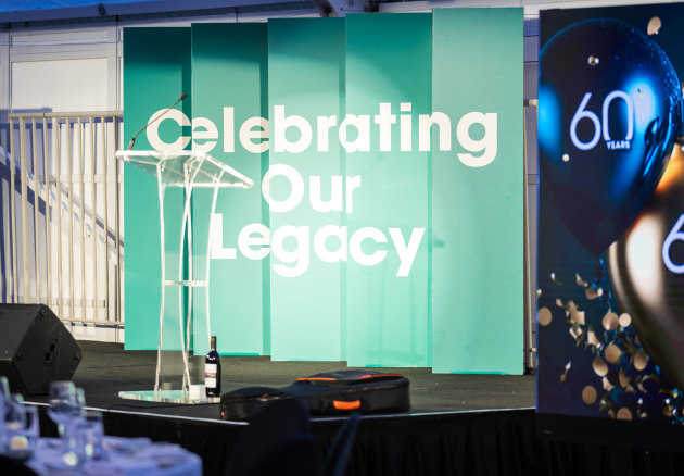 Ball & Doggett, in partnership with Resolution Imaging, produced a sustainable concertina-style sign, printed on fibre-based Envirocore White 20mm material, that created a striking stage backdrop to  deliver the &lsquo;Celebrating our legacy&rsquo; message facing one way, and &lsquo;AIP 60 Years&rsquo; facing the other.
