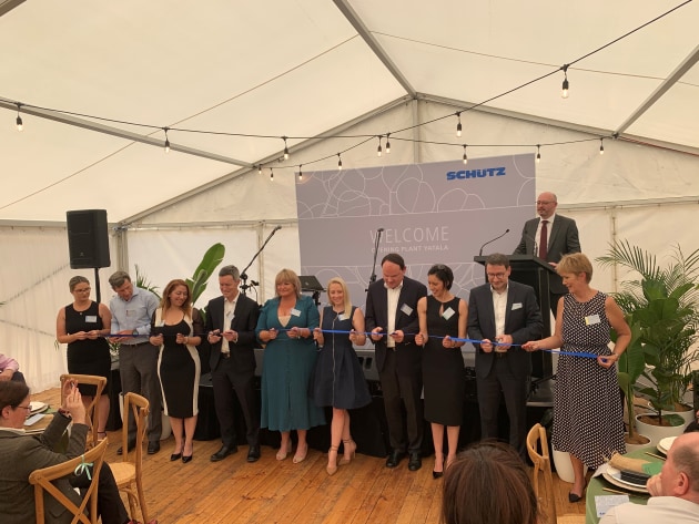 Making it official: The Schutz management team gathers for a collective ribbon cutting.
