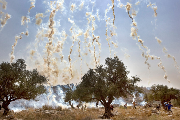 Documentary Single Image Winner. Israeli soldiers shoot tear gas during a demonstration against Israel's controversial separation barrier in the West Bank village of Nilin. Photo &copy; Cris Tola Olivares.