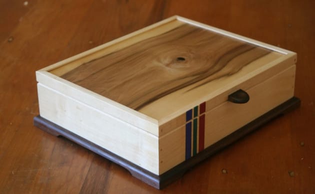 Brian Dawson, Medal box made from English sycamore. The lid is veneered with Tasmanian sassafras on the outside and West African zebrawood on the inside. The base is Tasmanian blackwood. The coloured vertical stripes in blue, red and green represent a medal ribbon. The box is finished in shellac and oil and the dimensions are 320 x 250 x 75mm.