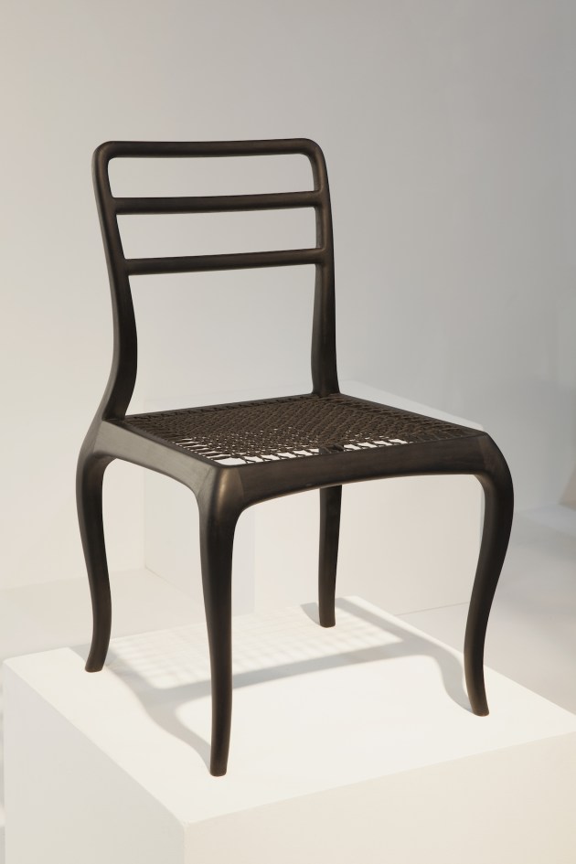 Eve chair by Andrew Dominic: A challenging chair to design and make, the Eve chair combines Andrew Dominic&rsquo;s paired down cabriole leg with an ergonomic backrest, achieving an aesthetic balance between antique and contemporary. Dominic has kept the joining elements as seamless as possible and rounded the outer reaches, which help soften the shapely lines. With curves being 'thirsty' on timber, it helps that the timber is sourced from sustainably-managed American hardwood forests. The Eve chair on show is elegant in ebonized Cherry, with a fine geometric weave spanning the seat. The Eve chairs will be made to order in American ash, cherry, oak or walnut, with the option of an upholstered version available.