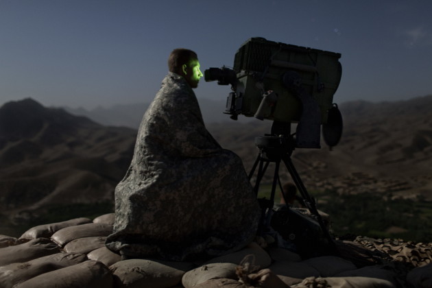 A US Army soldier surveys a road with a Long Range Acquisition Sight, on an observation post in the Tangi Valley, Wardak Province, Afghanistan, 2009.