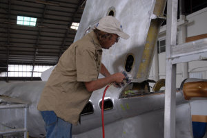 An aircraft maintainer works on the tail of an executive jet. (Steve Hitchen)