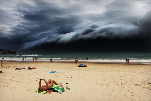 Nature, 1st prize singles. &copy; Rohan Kelly, Australia, 2015, Daily Telegraph. Storm Front on Bondi Beach.
A massive 'cloud tsunami' looms over Sydney as a sunbather reads, oblivious to the approaching cloud on Bondi Beach, Sydney, Australia on 6 November
2015.