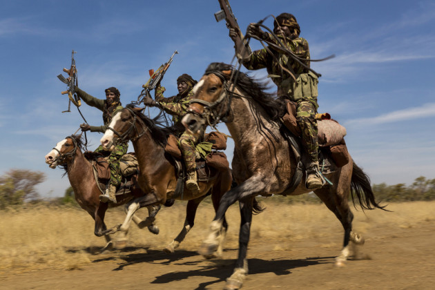 Nature, 2nd prize stories. &copy; Brent Stirton, South Africa, 2015, Getty Images for National Geographic. Rangers exhibit their riding skills as they return to Zakouma National Park after weeks on elephant patrol. Zakouma, Chad, 7 January 2015.