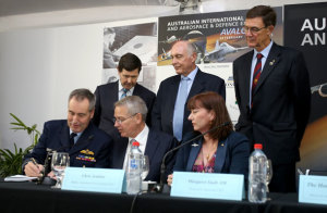 Thales Australia signed on to start work on the One SKY civil-military air traffic system in conjunction with the ADF and Airservices Australia. Here Air Marshal Geoff Brown signs the contract in front of (back row) Minister for Defence Kevin Andrews, Minister for Infrastructure and Regional Services Warren Truss, Chairman of Airservices Sir Angus Houston, (front row) Thales Australia CEO Chris Jenkins and Airservices CEO Margaret Staib. (Airservices Australia)