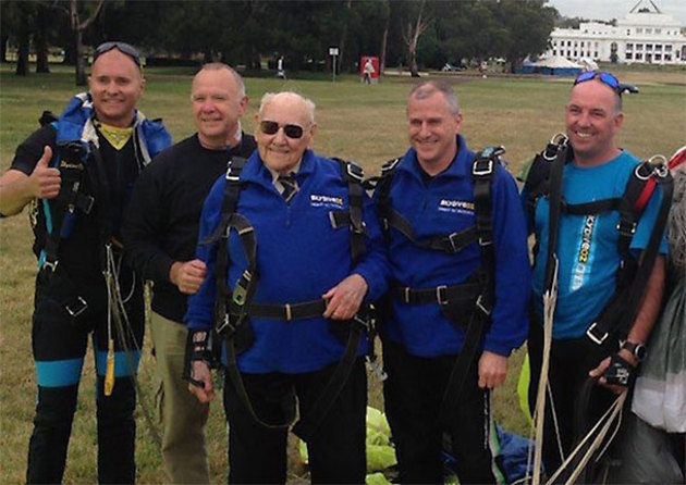 Safeskies President Emeritus Peter Lloyd (centre) after a tandem skydive over Canberra to celebrate his 95th birthday. (Safeskies)