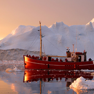 A traditional workboat ferries tourists on a midnight cruise among the spectacular ice formations of the Illulisat Icefjord, Greenland. Canon EOS 7D, 24-105mm lens @ 55mm, 1/80s @ f/4, ISO 250.